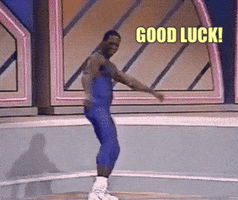 Video gif. A man in a leotard wiggles his hips and runs in place with high steps while staring at us with a charismatic grin.