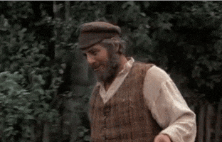 Movie gif. Topol as Tevye in Fiddler on the Roof sets a jug in the back of a wagon as he rests his arms on top of it. Text, "Let me tell you!"