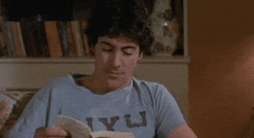 Video gif. Man is peacefully reading a book before he suddenly yells, "Jesus Christ!" He drops the book and falls to his knees, clawing at his face while screaming to the heavens, "Why!? God! Why!?," which appears as text. His anguish continues to escalate as he stands up and rips open his shirt.