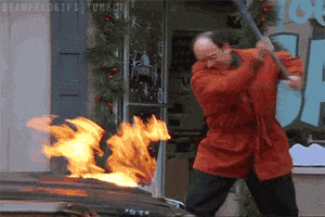Seinfeld gif. Jason Alexander as George frantically whacks the hood of a car on fire with a corn broom that also catches fire.