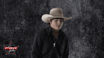 Sports gif. Dylan Smith, a professional bull rider, wears a cowboy hat and raises his arms up, shrugging deeply.