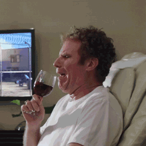 Beroemdheid gif.  Will Ferrell stuitert op een trillende stoel terwijl hij probeert te nippen aan een wijnglas dat over zijn voorkant loopt.