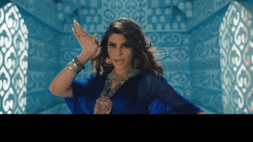 Music video gif. From the Badshah music video "Paani Paani." We zoom out on a woman in a blue dress, posing in ankle-high water in a large, light blue room resembling a palace. Yellow text at the bottom rushes in: "Mar jawaan."
