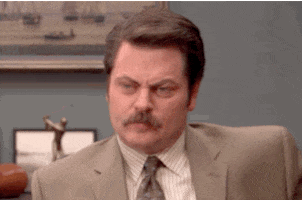 Parks and Recreation gif. Nick Offerman as Ron exhales heavily and shakes his head confused as if giving up. 