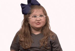Video gif. A little girl wearing a large blue bow and white-rimmed glasses gives us a giggling thumbs up.