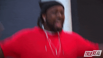 Reality TV gif. A Rapper on The Rap Game jumps around excitedly, waving his hands in the air. He smiles widely and looks around with wide eyes.