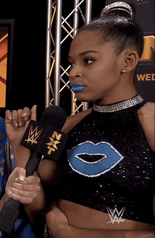 Sports gif. WWE wrestler Bianca Belair walks away from person holding a microphone, giving them the side-eye.