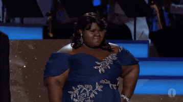 Celebrity gif. Gabourey Sidibe at The Academy Awards. She's putting her hand on her hip and posing for the audience while looking stunning in her dress.  