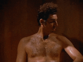Seinfeld gif. Michael Richards as Kramer is shirtless and sweating in a sauna. He checks the sweat on his arm and says, "It's like a sauna in here," which appears as text. Doh.