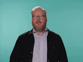 Celebrity gif. Jim Gaffigan looks at us a bit suspiciously with an eyebrow cocked. He slowly pulls off his glasses and smirks, nodding his head. He then gives us a big thumbs up.