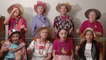 Video gif. Group of badass grandmas wearing floral shirts and gardening hats all give us the middle finger and say, "Fuck you!"