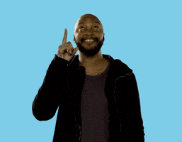 Video gif. A man looks up, sticking his point out, and points up to the sky with his finger. 