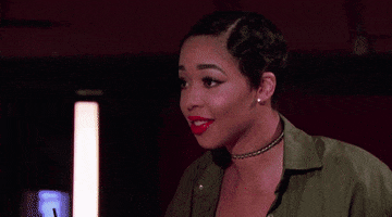 Reality TV gif. Two women from Basketball Wives LA high five, one raising her hand confidently and the other accepting the high five after a moment of consideration.