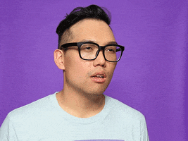 Video gif. Man wearing glasses squints at something and puts a pair of binoculars up to his eyes.