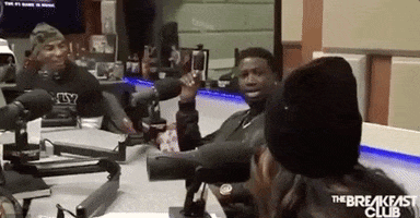 Celebrity gif. Rapper Gucci Mane sits in front of a microphone on The Breakfast Club, frozen in astonishment.