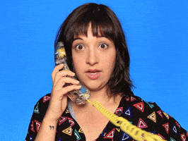 Video gif. Woman holds a telephone to her ear, staring at us wide-eyed and mouthing "wow."