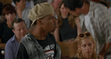 Movie gif. A scene from Half Baked. In an auditorium full of seated people, a standing man in a backward beige cap points at us as he speaks. Text, "Boo this man!" The man pulls off his hat and throws it, stirring the crowd to throw more things. Scrolling text, "Boo."
