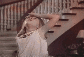 Movie gif. Mary-Kate Olsen as Amanda in It Takes Two presses the back of her hand to her forehead and faints, falling theatrically to the floor at the bottom of a fancy staircase.