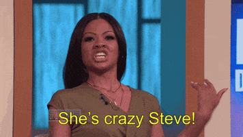 Reality TV gif. Steve Harvey winces as a woman yells at him with flailing arms. Text, "She's crazy Steve!"
