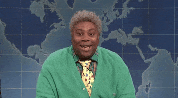 SNL gif. Kenan Thompson, dressed as a senior man in a bright green cardigan and a multicolored necktie, face frozen in an overly-friendly smile. 