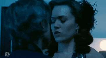 TV gif. Mandy Moore as Rebecca Pearson in This Is Us flinches away from Sam Trammel as Ben's kiss.