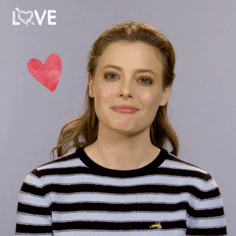 Celebrity gif. Gillian Jacobs looks emotional as she says, “awww!” A drawing of a heart throbs next to her.
