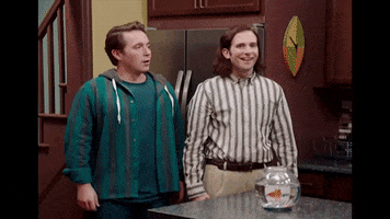 SNL gif. Beck Bennett and Kyle Mooney, in a kitchen, high five each other and shake hands, then turn to individually high-five Larry David, who is wearing a backwards baseball cap and holding onto a six-pack.