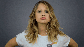 Celebrity gif. Debby Ryan pouts her lips and bends forward to give us a kiss from a distance.