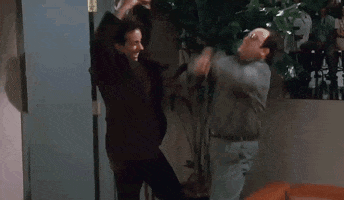 Seinfeld gif. Jerry Seinfeld as Jerry and Jason Alexander as George bend their knees and pump their fists in excitement.