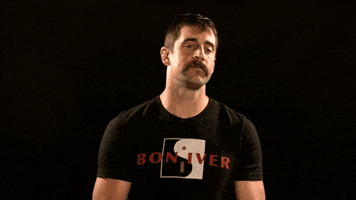 Sports gif. Aaron Rodgers from the Green Bay Packers looks at us with confidence as he brushes dust off his shoulder. A puff of dust is edited in, so everytime he brushes his shoulder, it looks like dust really does fly off.