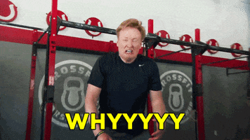 Celebrity gif. Conan O'brien stands in front of CrossFit weights. He drops to his knees and covers his face with his hands while screaming in agony. Text, "WHYYYYY".