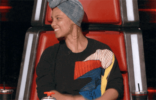 Reality TV gif. A smiling Alicia Keys on The Voice claps her hands together enthusiastically.