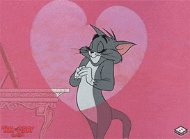 Cartoon gif. Tom Cat of Tom and Jerry closes his eyes and coyly rests a cheek on clasped hands, then smiles nervously as hearts blink around him. 