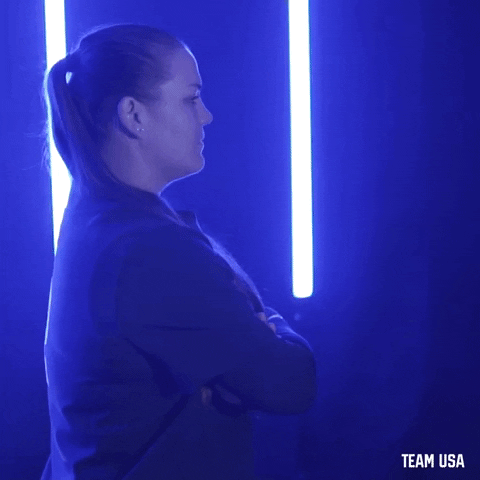 Sports gif. Taylor Edwards, from Team USA Softball, has her arms crossed and she turns to face us.
