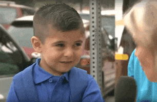 Meme gif. Little boy being interviewed by a KTLA reporter, smiles and laughs but then starts crying, covering his face with his hands.