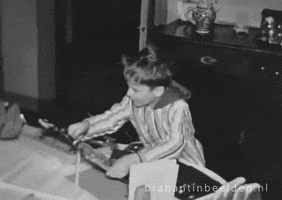 Video gif. Black and white home-movie style video of a young boy wearing a long night shirt looking at us while jumping and clapping with excitement. Text, "Yay."