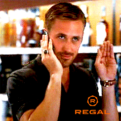 Movie gif. Walking through a liquor store in character, Ryan Gosling holds a cellphone to his ear and waves politely with his other hand and smiles.