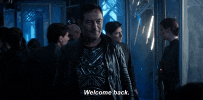 TV gif. Jason Isaacs as Gabriel Lorca in Star Trek Discovery. He stands in the ship and stares someone down with a small smile on his face as he says, "Welcome back."