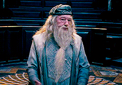 Dumbledore in the ministry courtroom, shrugging and then putting his hands on his hips