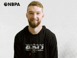 Video gif. Domantas Sabonis of the Indiana Pacers flexes his arm muscle at us against a white and black digitized background. The NBPA logo appears in the top corner.