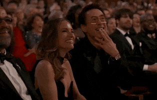 Oscars 2024 GIF. Susan and Robert Downey Junior, seated at the Oscars, Robert pointing at the performer as they privately enjoy the moment together.