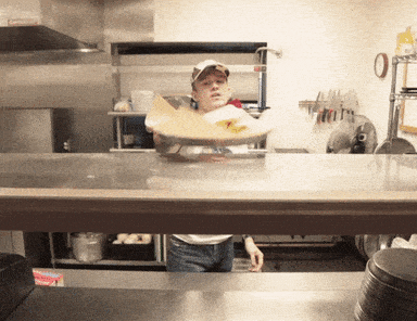 Cooks working the pass in a busy restaurant kitchen, plating dishes whose recipes are never published anywhere