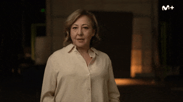 Celebrity gif. Carmen Machi stands in a warehouse and says calmly, "Más de 183 días," which appears as text. Her face slowly breaks into a smile. 