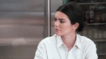 Reality TV gif. Kendall Jenner from Keeping Up With The Kardashians raising her eyebrows and looking away, choosing to disregard the situation and sipping her tea.