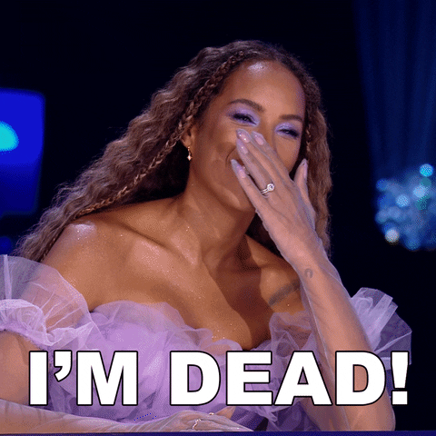 Reality TV gif. Leona Lewis on Queen of the Universe laughs and covers her big smile before saying "I'm Dead!"