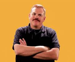 Video gif. Kevin Heffernan stands with his arms crossed and shakes his head disapprovingly.