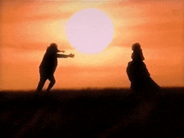 Music video gif. From Cuco's video for Sitting in the Corner, silhouetted by a warm sun, a man and a woman run towards each other like they're going to embrace, but then run past each other.