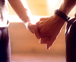 Video gif. Up-close shot of two men's hands clasped together tightly.