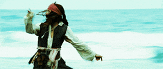 Movie gif. Johnny Depp as Jack Sparrow in Pirates of the Caribbean sprints down a beach with his arms flailing as he turns to swat something behind him.