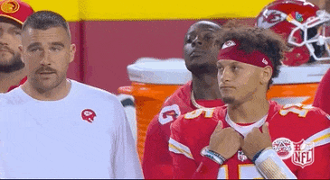 Sports gif. Travis Kelce and Patrick Mahomes of the Kansas City Chiefs stand on the sidelines shaking their head and looking totally bummed at something happening on the field. 